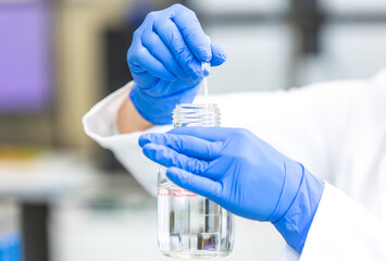 Wall Mural - Young woman scientist holding test tube with lab glassware, science laboratory research and development concept, laboratory research