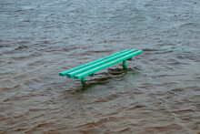 The Bench Is In The Water. Beach Or Park Flooded