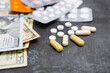 © O.Farion - White round pills, capsules, blister packs with tablets, antibiotic, painkiller or drugs and money, US dollar banknotes, expensive medicine and healthcare concept, close-up view