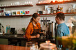 © Drobot Dean - Woman training man with down syndrome to work as barista in coffee shop