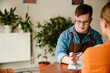 © Drobot Dean - Man with down syndrome writing down notes during internship in cafe