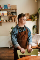 Wall Mural - Man with down syndrome smiling while working in cafe