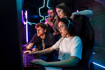 Wall Mural - Group of people watching their friend playing video game in cybersport club