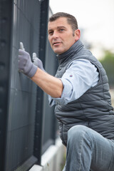 Wall Mural - worker installing welded metal mesh fence