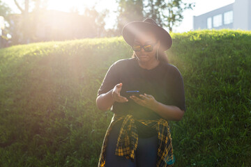 Happy smiling african woman holding phone in urban city