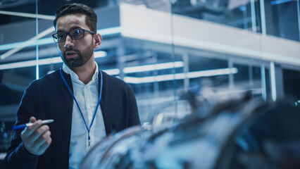 Fototapete - Smart Chief Engineer in Glasses Explaining the Advanced Technology of a Modern Innovative Industrial Invention to a Team of College Students on an University Course.
