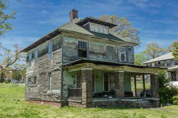 Wall Mural - Old abandoned two story wooden home with large front porch left to rot on sunny day