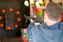 teenager with a rifle in a funfair