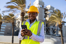 Black Woman Builder On Smartphone On Street