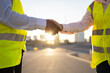 © ADDICTIVE STOCK - Crop engineers in site waistcoats shaking hands on street