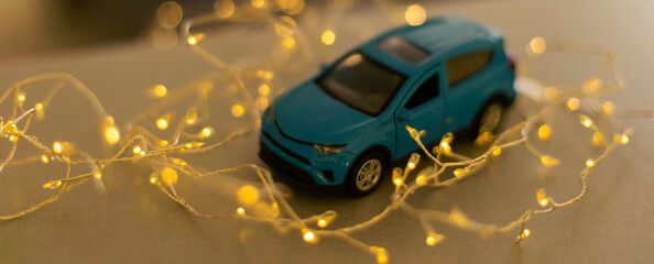 Wall Mural - Miniature Car on colorful bokeh background. Holiday Merry Christmas concept.