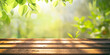 Spring summer beautiful natural background with green foliage in sunlight and empty wooden table outdoors.
