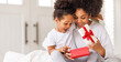 © JenkoAtaman - happy mother's day. african american baby daughter giving  gift box to her mom for holiday at home