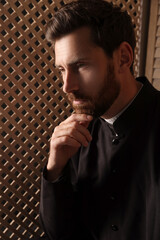 Wall Mural - Catholic priest wearing cassock in confessional booth