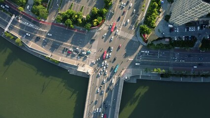 Canvas Print - Drone footage of a crossroad with traffic, river and trees with sunlight