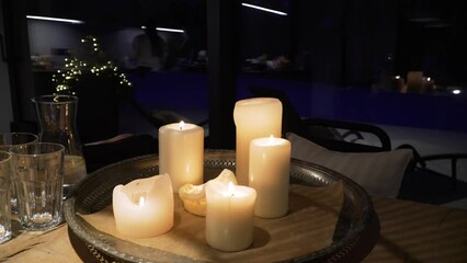 Wall Mural - Lit candles on a metal tray on a wooden table