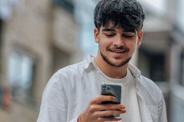 Canvas Print - young man in the street looking at the mobile phone