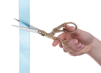 Wall Mural - Woman cutting ribbon with beautiful scissors on white background, closeup