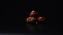 3 Chestnuts Rotating In Front Of A Black Background