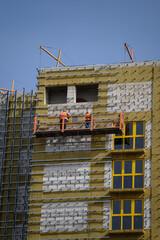 Wall Mural - Workers sheathe the outer walls of the building with insulation.Insulation of the facade of the building.Exterior finish