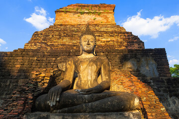 Wall Mural - Ruined pagoda and Buddha statue in ancient city at Sukhothai Historical Park, world heritage, Thailand