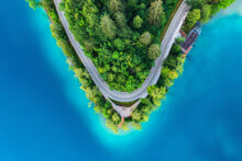Aerial View Of Road Near Blue Lake, Forest At Sunrise In Summer. Bled Lake, Slovenia. Travel. Top View Of Beautiful Road, Green Trees In Spring. Landscape With Highway And Sea Bay. Road Trip. Nature