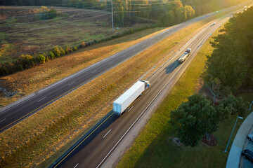Wall Mural - Aerial view of busy american freeway with fast moving cars and trucks. Interstate hauling of goods concept