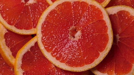 Wall Mural - Grapefruit slices rotating. Closeup fruit background. Nobody