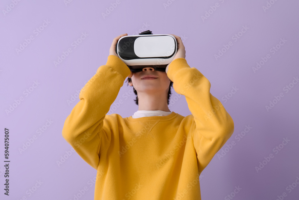 Teenage boy in VR glasses on lilac background
