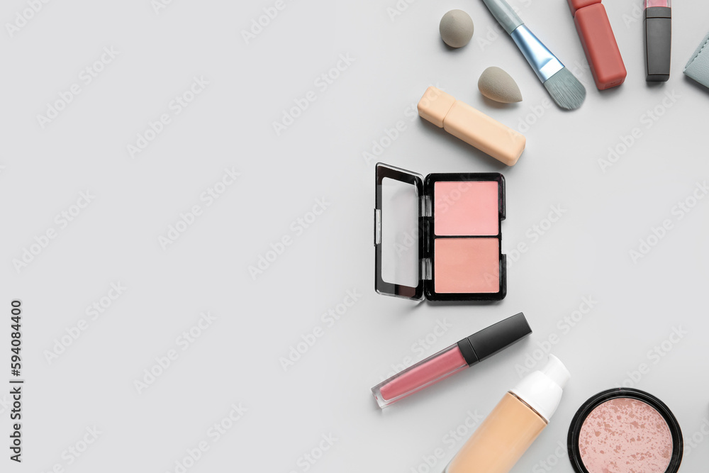 Frame made of decorative cosmetics with sponges and brush on light background