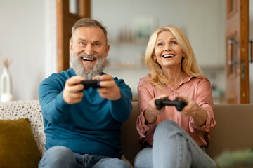 Wall Mural - Senior Couple Playing Videogame Online Having Fun Together At Home