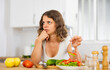 © JackF - Portrait of displeased woman in nightie eating salad in kitchen at home. Dissatisfied woman having healthy dinner.