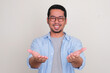 Adult Asian man smiling happy with both hand doing giving something pose