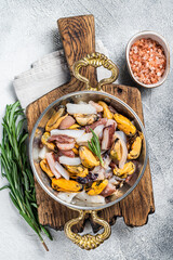 Wall Mural - Mixed Seafood, variation of fresh mussels, clams, squid, octopus, shrimps and prawn in a skillet. White background. Top view