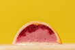 Close up of homemade orange chocolate bonbon slice. Assortment of hand painted candies. Candy cut in a half. Mockup with a copy space. Macro shot of  chocolatier products on yellow background
