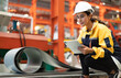 © Nassorn - Latin engineer wears safety helmet work in heavy metal engineering factory. Young female hispanic worker in hardhat hard hat checking production machinery equipment in metalwork manufacturing facility