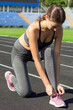 young beautiful sport runner woman tying her shoe sneaker laces, ready for running, sport and fitness concept