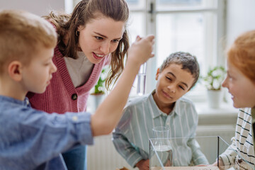 Sticker - Young teacher making little greenhouse with their pupils, learning them about planting.