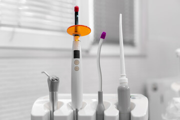 Close-up of dental instruments near the dental chair. Ultraviolet, saliva pump, water and air supply apparatus