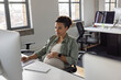 © ReeldealHD images - Pregnant businesswoman working at a desktop computer in an office smiling