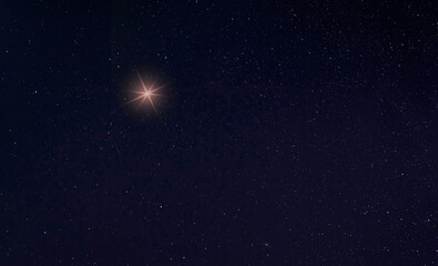 Wall Mural - Christmas star rising on a starry night