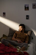 © pressmaster - Young guy worried about his life problems sitting alone on bed in the room