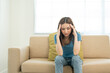 © Chanakon - Depressed and Stressed asian woman on sofa. Crying sadness female alone in home problem in life. Unhappy asian woman headache Upset frustrated by problem love relationship feeling despair and anxiety