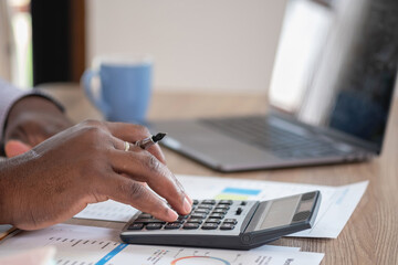 Wall Mural - African black businessman sitting doing a financial report and studying annual profit analysis An accountant checking the financial status of the company is in the office.