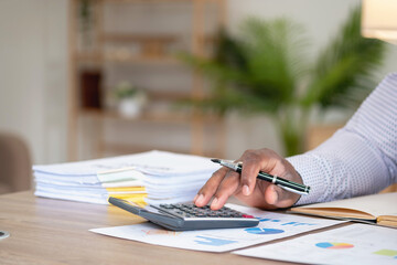 Wall Mural - African black businessman sitting doing a financial report and studying annual profit analysis An accountant checking the financial status of the company is in the office.