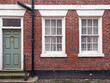 © Philip J Openshaw  - front view of a typical old english terraced brick house with yellow painted walls and maroon window and doors
