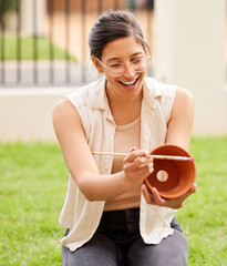 Poster - Almost all creativity requires purposeful play. s young woman painting a pot in the garden at home.