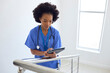 © Monkey Business - Female Doctor Or Nurse With Digital Tablet Checking Patient Notes On Stairs In Hospital
