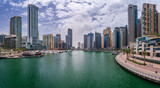 Fototapeta  - Panorama of tall apartment blocks surround the water at Dubai Marina in the UAE
