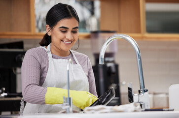 Sticker - Dishes are relaxing to do sometimes. a young woman doing the dishes at home.